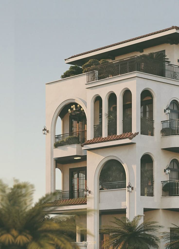 White multi-story Mediterranean villa featuring arched verandas and palm landscaping