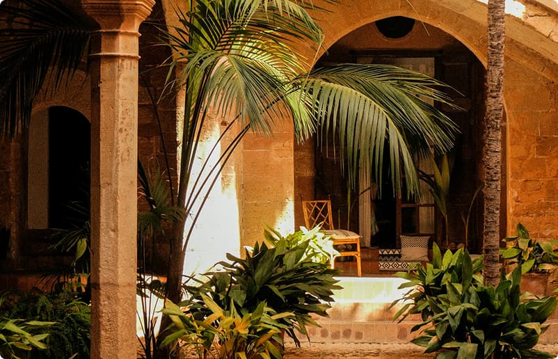 Historic architectural courtyard with palm trees and terracotta colonnades