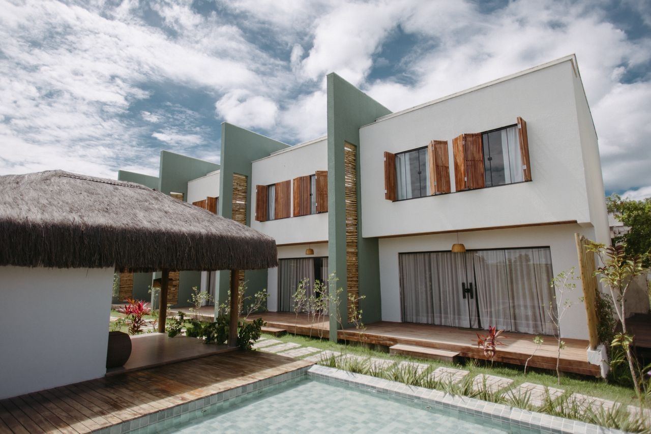 Contemporary villa with timber shutters, thatched outdoor gazebo, and swimming pool