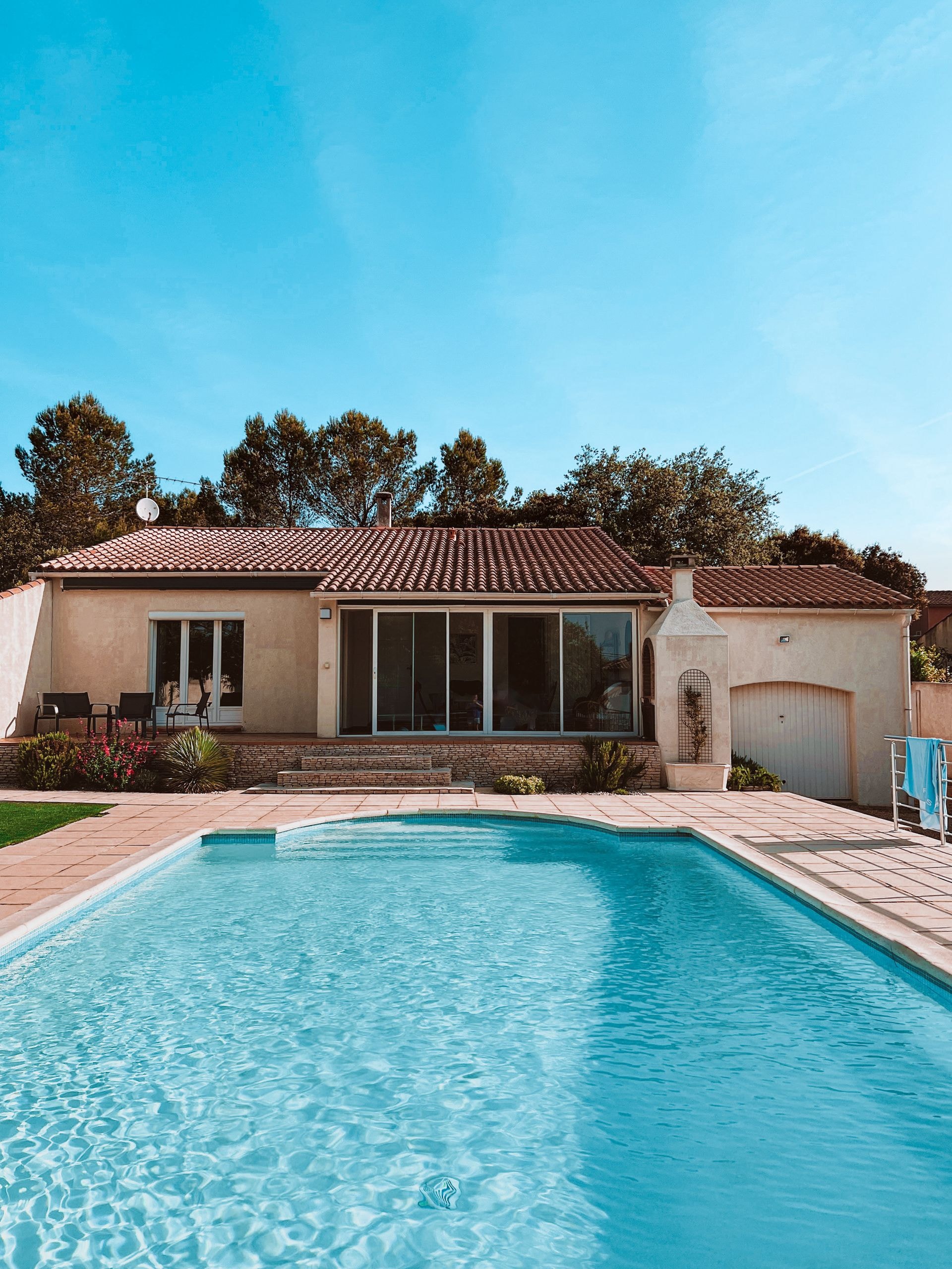 Sprawling single-story villa with a large turquoise pool and lush private courtyard garden